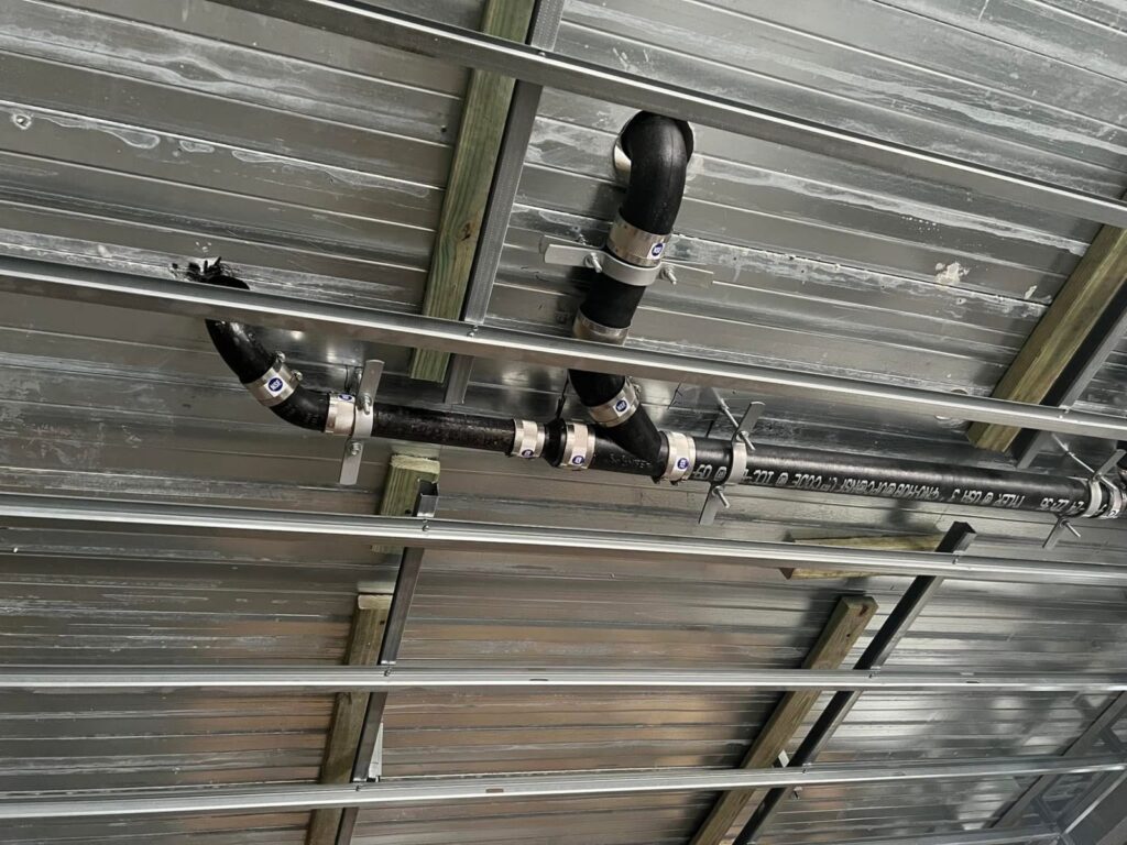 Overhead drain and vent piping in a commercial space