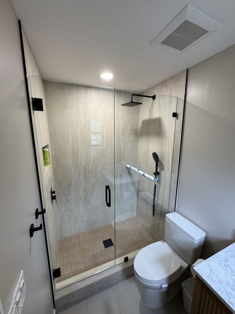 Remodeled bathroom with a frameless glass shower and new toilet