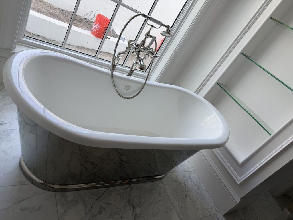 Pedestal soaking tub with a floor mounted tub filler