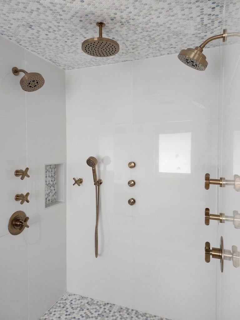 Luxury shower with a rain head, handheld shower and brushed gold body sprays